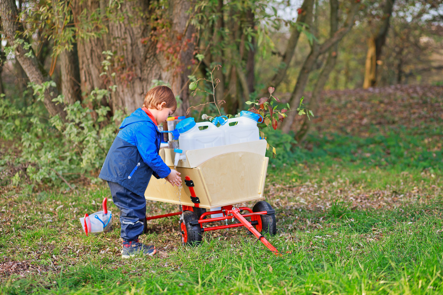 Kind wäscht die Hände am Wassertank des Forschermobils