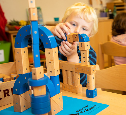 Kind konstruiert Bauwerk mit Magneten