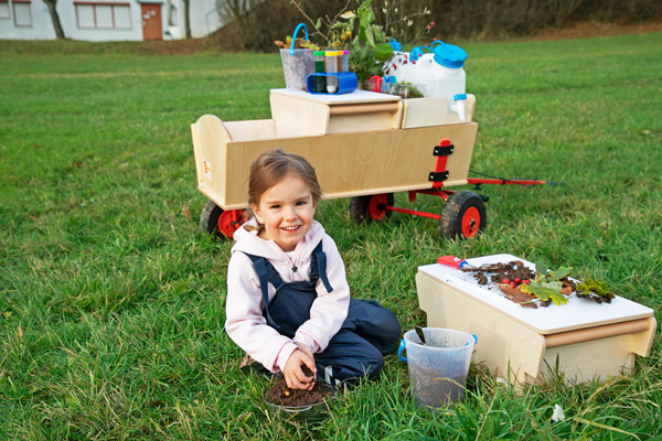 Kind mit Forschermobil auf der Wiese