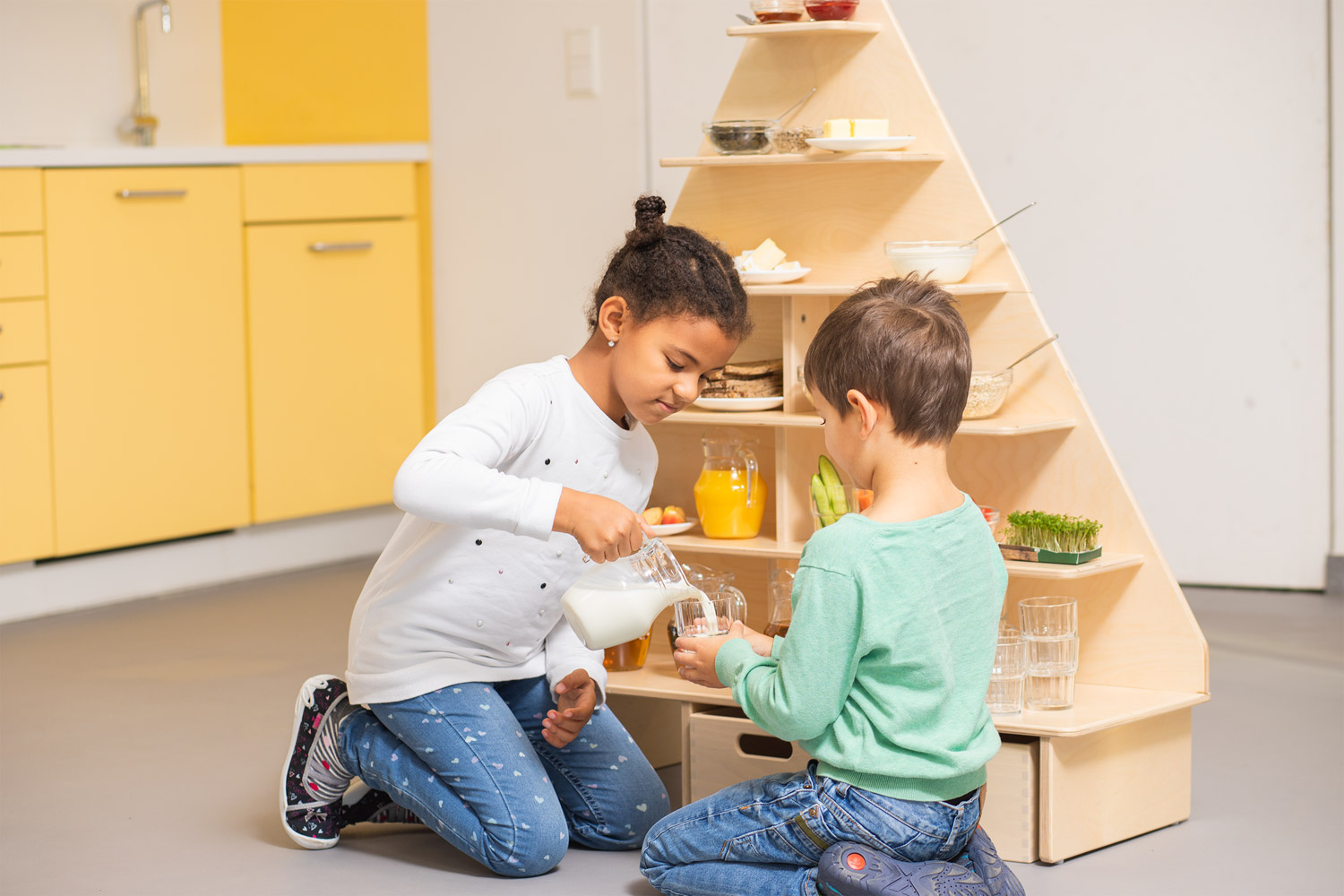 Kinder spielen mit der Ernährungspyramide