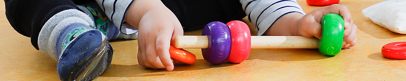 Kinder beim Stecken von Ringen auf einen Stab