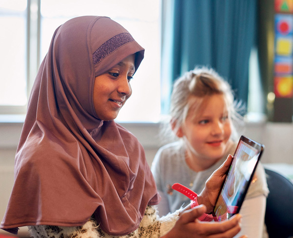 Interkulturelle Zusammenarbeit Kind mit Kopftuch am Tablet