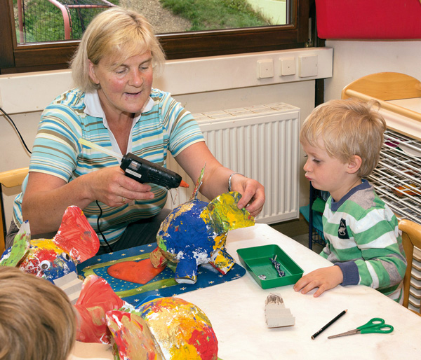 Basteln Erzieherin mit Kind beim Basteln