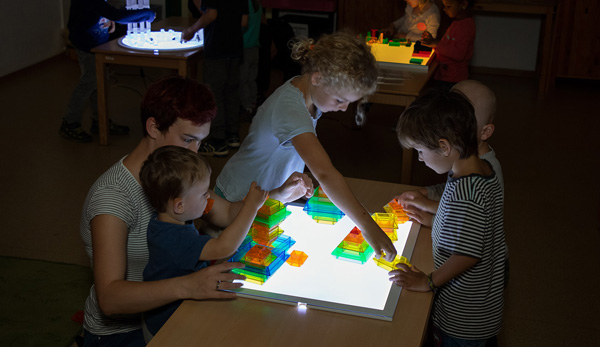 Kinder spielen im Dunkeln mit Lichtbausteinen