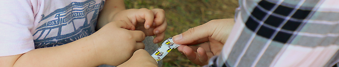 Kindergärtner versorgt Kind mit einem Pflaster