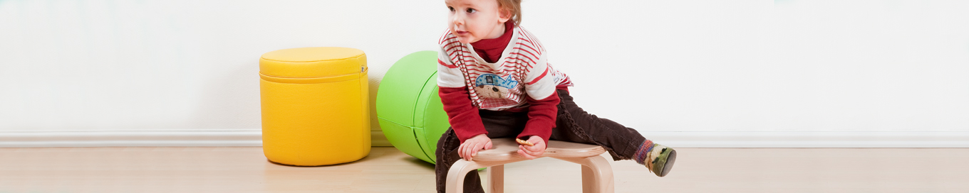 Ein Kind sitzt auf einem Hocker