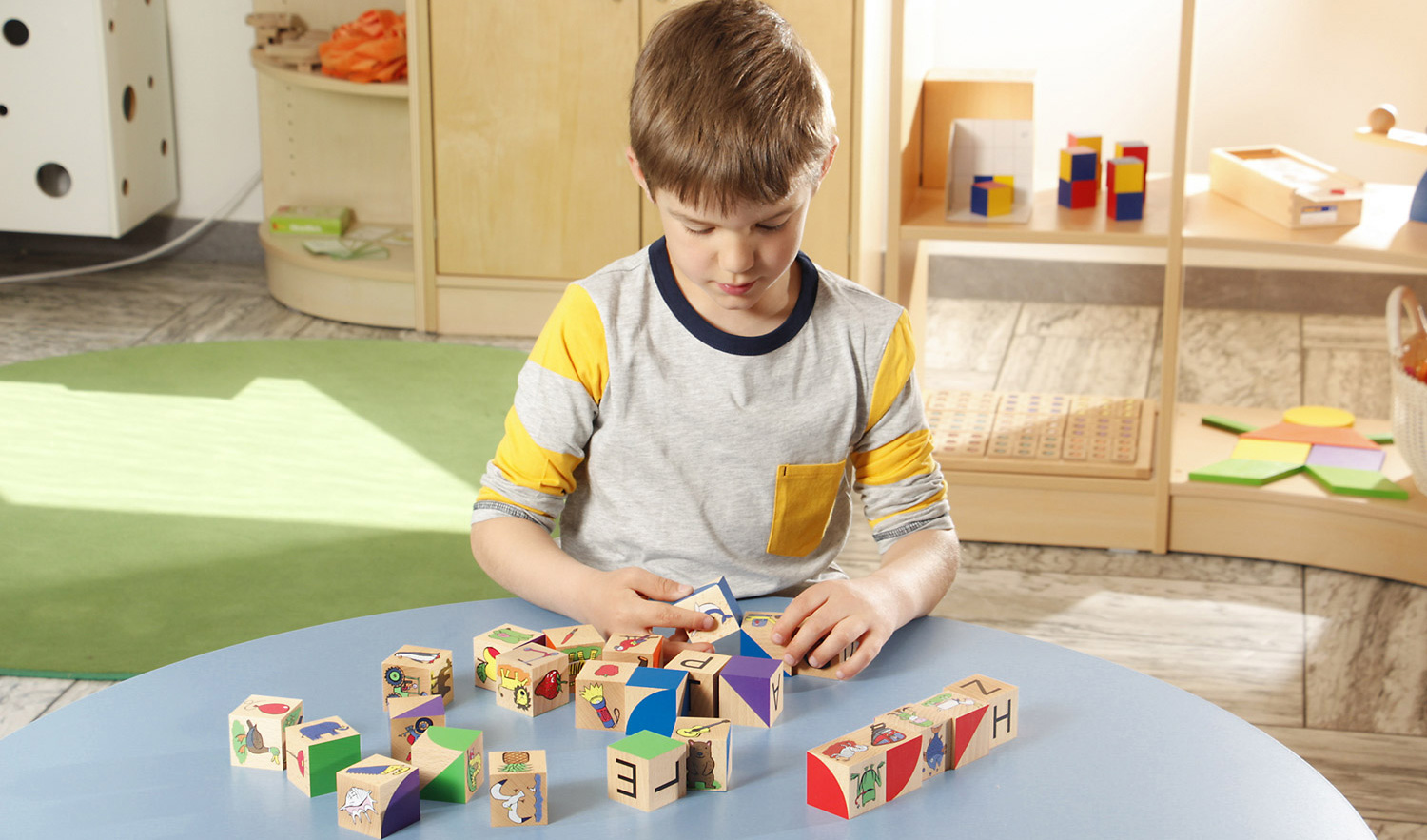 Anlautwürfel Schüler spielt mit Anlautwürfel