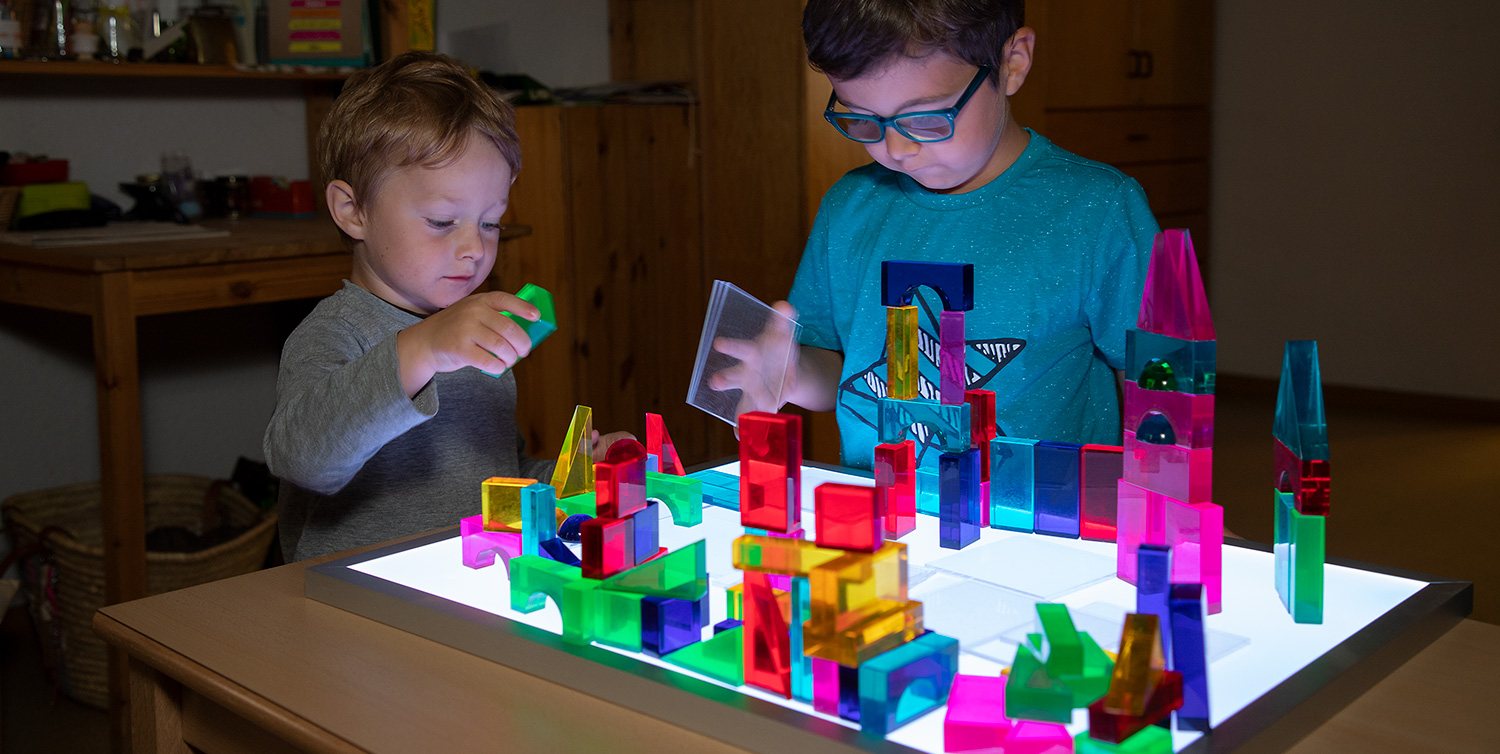 Luxy Leuchtbausteine Kinder konstruieren eine farbenprächtige Lichterstadt mit Luxy Leuchtbausteinen