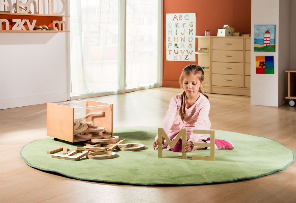 Kind spielt mit BuchstabenRiesen aus Holz