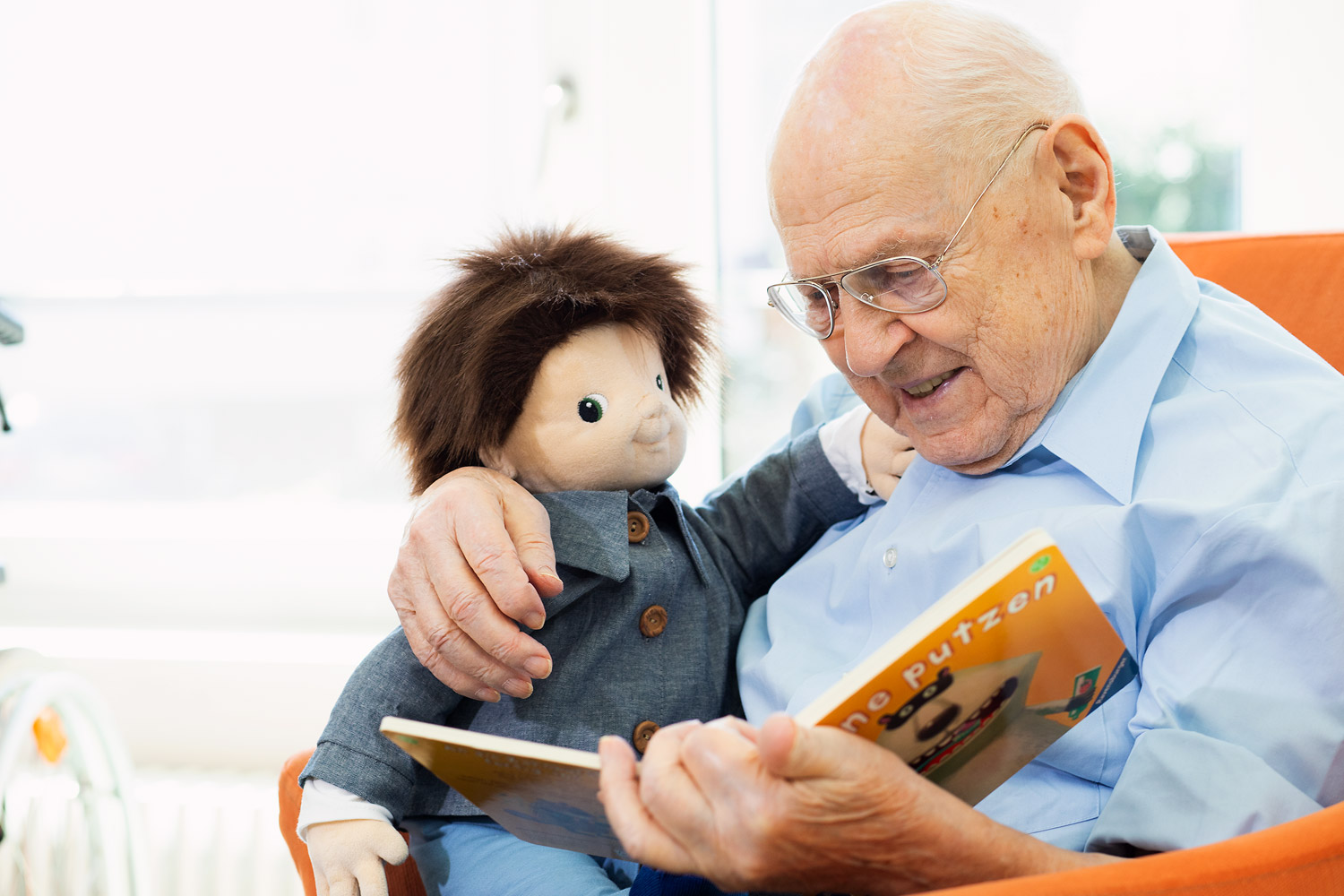 JOYK Empathiepuppe  Senior liest Joyk® Empathiepuppe etwas vor