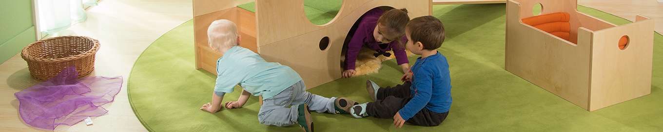 Kinder krabbeln durch eine Spielhöhle