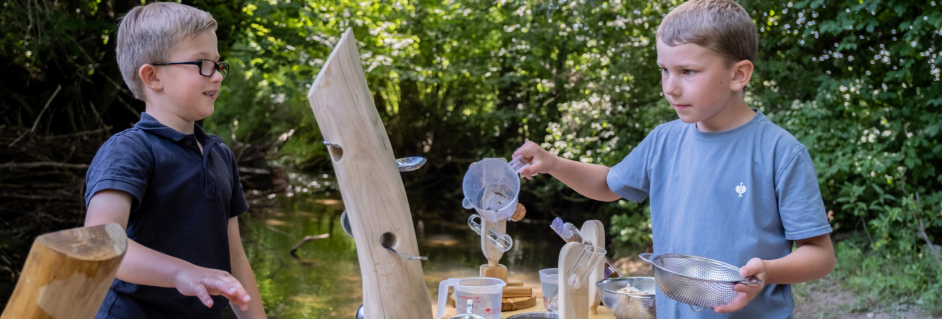 Draussen entdecken - Kalalier Jungs spielen an der Kalalier Entdeckerstation mit Wasser.