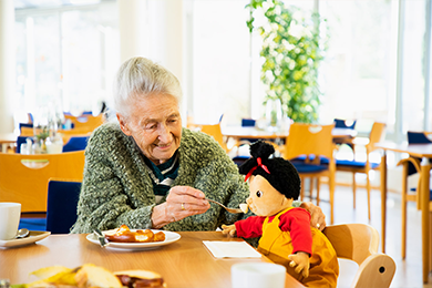 Empathiepuppen Seniorin füttert Puppe